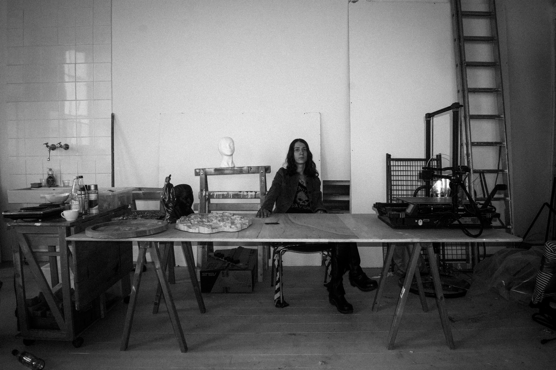 At the studio table — between the kiln, the printer, and the ladder.