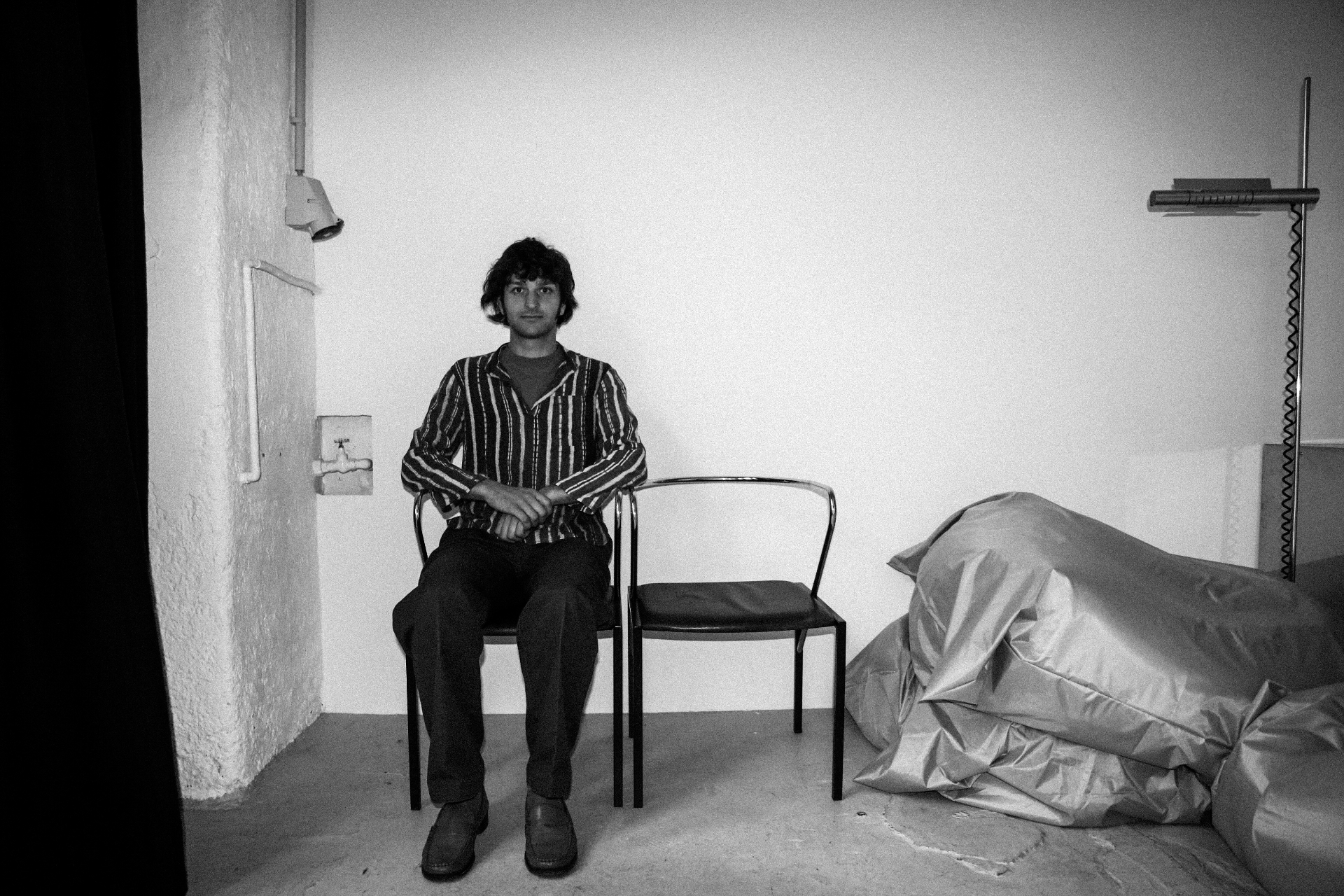 Sitting still — a quiet portrait between two chairs.