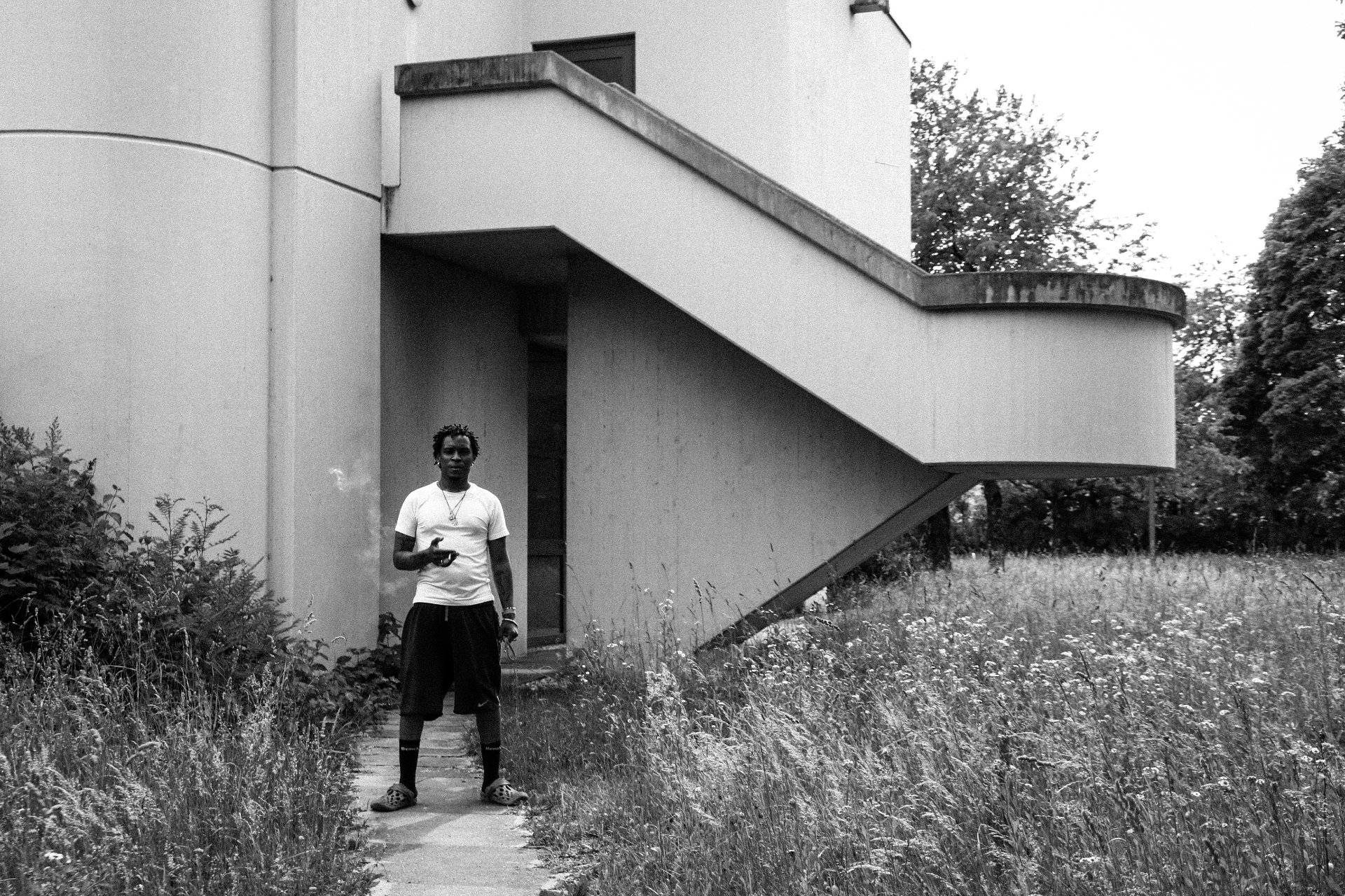 Outside the building — a modernist frame, an unhurried figure.